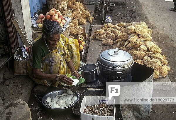 Eine alte Frau bereitet Idlis zu  Idlis am Straßenrand in Madurai  Tamil Nadu  Indien  Asien