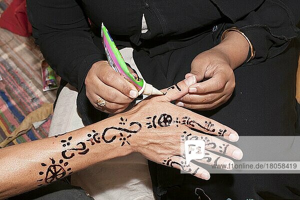 Woman painting hand with henna  Elephantine Island  Aswan  henna drawing  Egypt  Africa