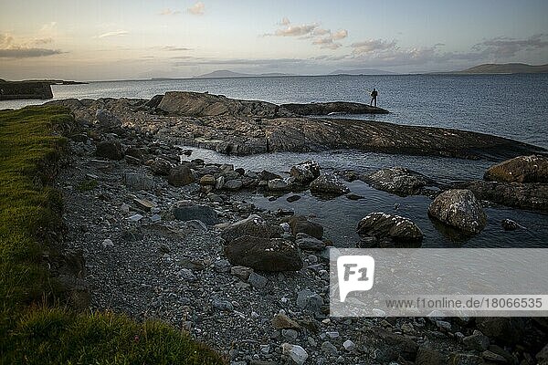 Mann beim Angeln vor dem Hafen von Renvyle an einem Sommerabend entlang des Wild Atlantic Way. Renvyle  Grafschaft Galway  Irland  Europa