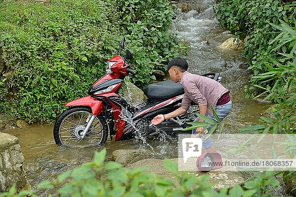 Junge wäscht Motorrad in Bach  Tha Pin  Vietnam  Asien