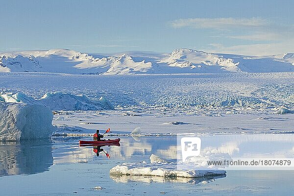 Kayaker in a red kayak on the glacier lagoon Jökulsárlón in winter  glacier lake in south-east Iceland