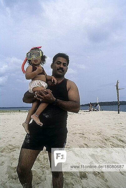 Father carrying his daughter in Jolly Buoy  Coral island  Andaman  India  Asia