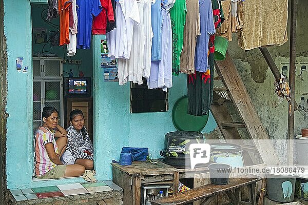 Indonesische Mutter und Tochter zu Hause mit Wäsche trocknend auf Wäscheleine in Kota  Old Batavia  Java  Indonesien  Asien