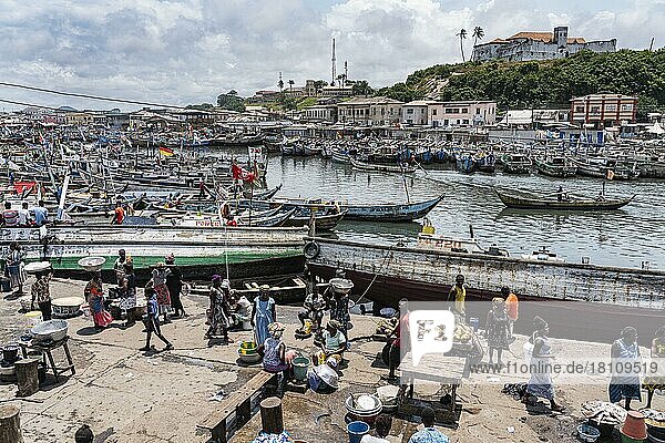 View  people  fish market  Elmina fishing port  Fort Conraadsburg or also Fort St. Jago in the back  Gold Coast  Ghana  Africa
