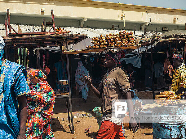 Ein Mann trägt Brot auf dem Markt eines Dorfes in der Nähe von Ayoun El Atrous  Hodh El Gharbi  Mauretanien  Wüste Sahara  Westafrika  Afrika