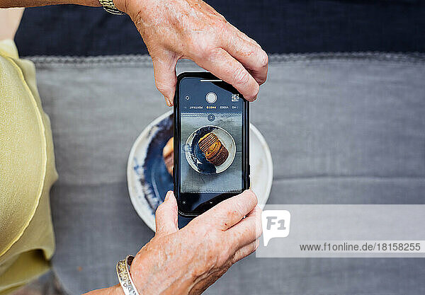 Rentnerin  die ihr Essen mit dem Handy fotografiert