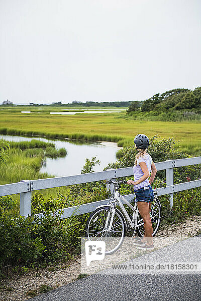 Junge Frau radelt durch Cape Cod Marshes Radweg