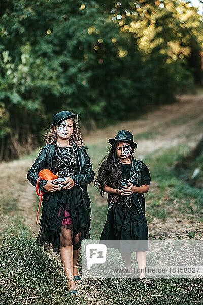 Teenager-Mädchen in Hardrock-Kostümen feiern Halloween-Party