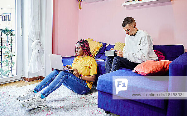 Ein gemischtrassiges Studentenpaar bereitet sich zu Hause auf Prüfungen vor. Teamarbeit.