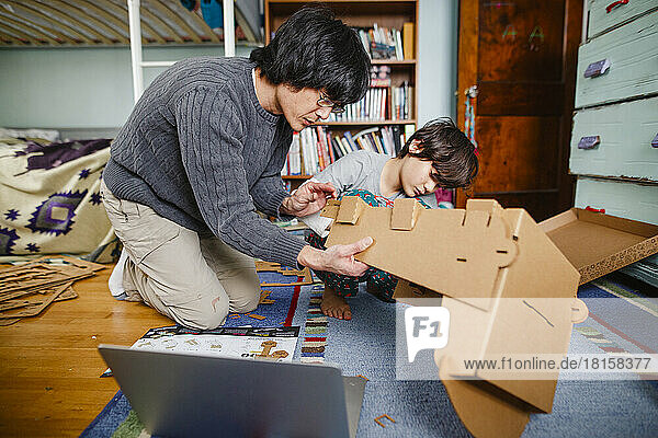 Ein Vater und sein Sohn bauen gemeinsam ein Bauwerk aus Karton