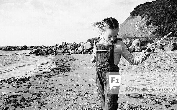 black and white picture of girl playing bat and ball at the beach