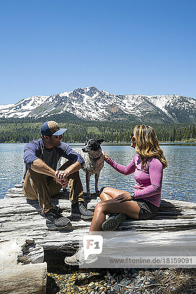 A couple with their dog on the shoreline of Fallen Leaf Lake.