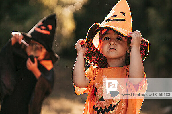 Zwei kleine Mädchen feiern Halloween im Naturkürbis