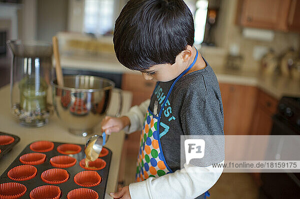 Ein kleiner Junge backt Cupcakes