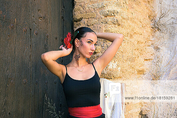 Frau in einem Flamenco-Kostüm vor einem Schlosstor sitzend