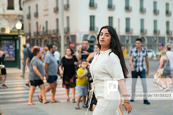 Business Latin Woman schaut in die Kamera umgeben von Menschen