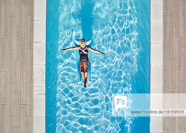 Frau schwimmt auf Wasser im Pool