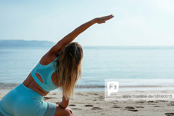 Frau macht Yoga-Übungen am Strand