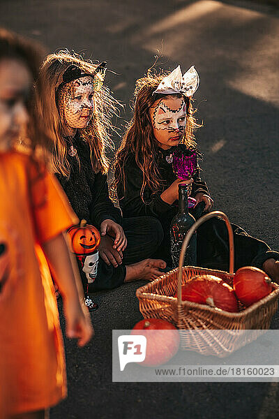 zwei kleine Mädchen  die als schwarze Katzen verkleidet eine Halloween-Party feiern