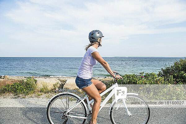 Junge Frau beim Radfahren an den Stränden von Cape Cod auf dem Küstenradweg
