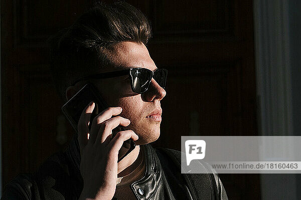 Young man wearing sunglasses talking on mobile phone
