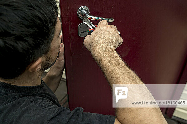Mann repariert Türschloss