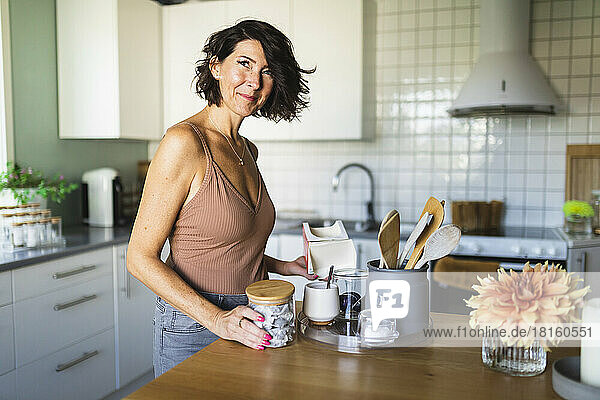 Smiling mature woman in front of kitchen island at home