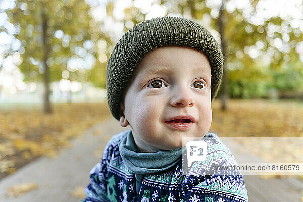 Cute boy with brown eyes wearing knit hat in park