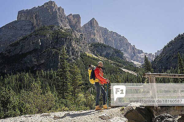 Hiker with backpack standing in front of Dolomites  Italy