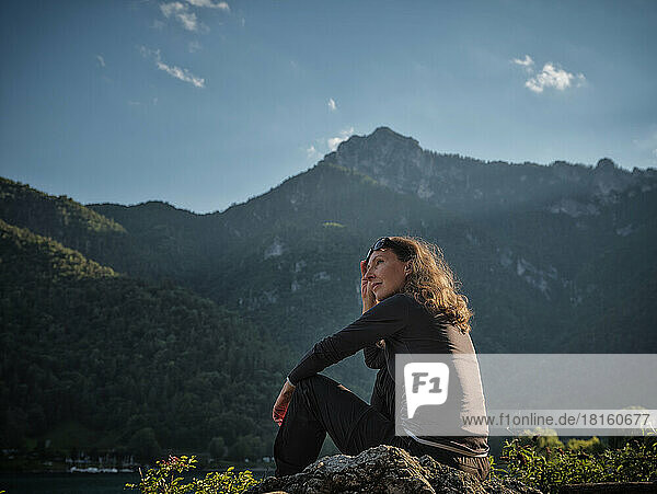 Smiling mature woman sitting on rock
