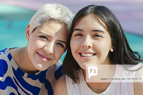 Glückliche junge Frau mit Freundin am Sportplatz an einem sonnigen Tag