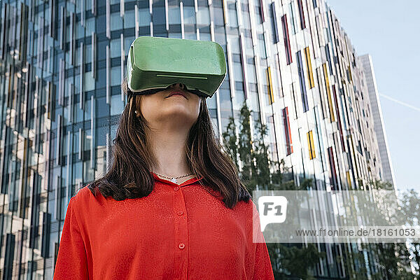 Junge Frau trägt Virtual-Reality-Simulator vor Gebäude