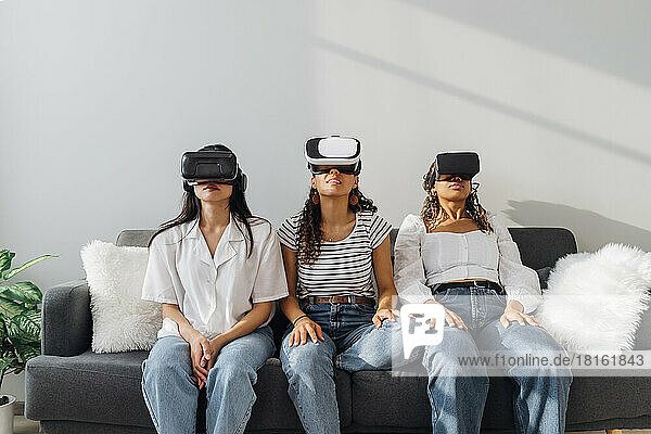 Young roommates watching through VR glasses at home