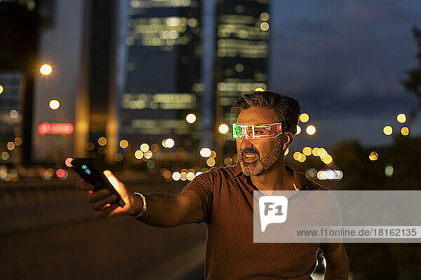 Happy businessman wearing smart glasses at night