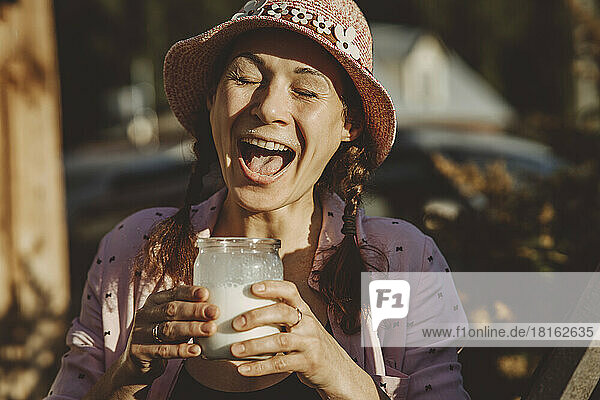 Reife Frau genießt an sonnigen Tagen frische Milch