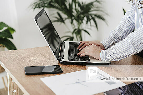 Junge Geschäftsfrau arbeitet im modernen Büro mit Laptop. Nahaufnahme