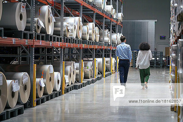 Businesswoman with colleague walking in warehouse