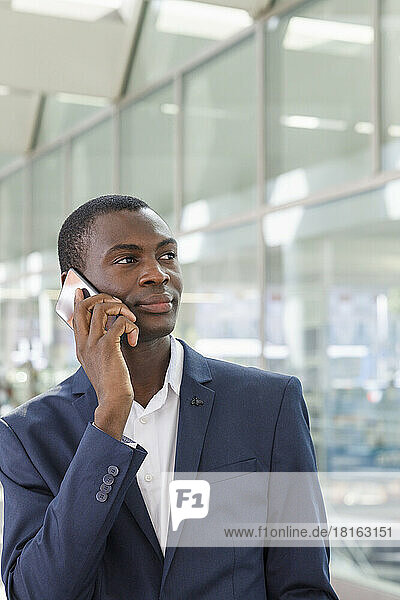 Businessman talking on smart phone at railroad station