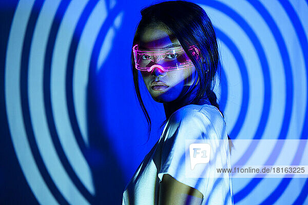Young woman with futuristic glasses under spiral shadow