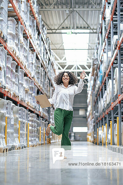 Happy businesswoman dancing and having fun in warehouse