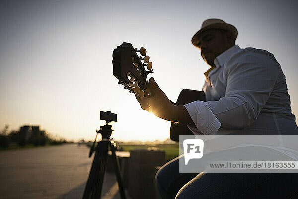 Guitarist playing guitar at sunset