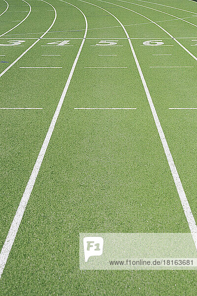 Numbers on empty running track at sports field