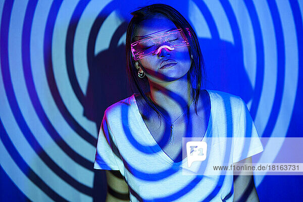 Spiral shadow on young woman wearing LED smart glasses