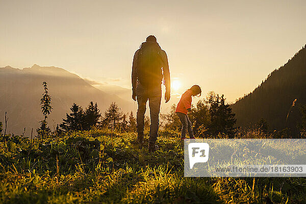 Man with daughter hiking on mountain