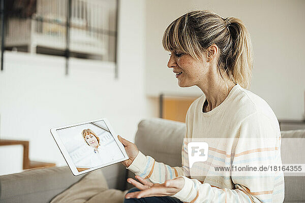 Frau macht Online-Konsultation mit Arzt über Tablet-PC zu Hause