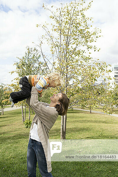 Glückliche Mutter spielt mit Sohn im Park