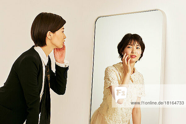 Junge Japanerin schaut in den Spiegel