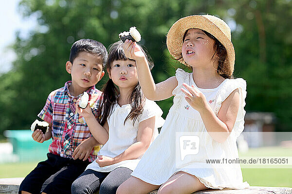 Japanese kids eating at a city park