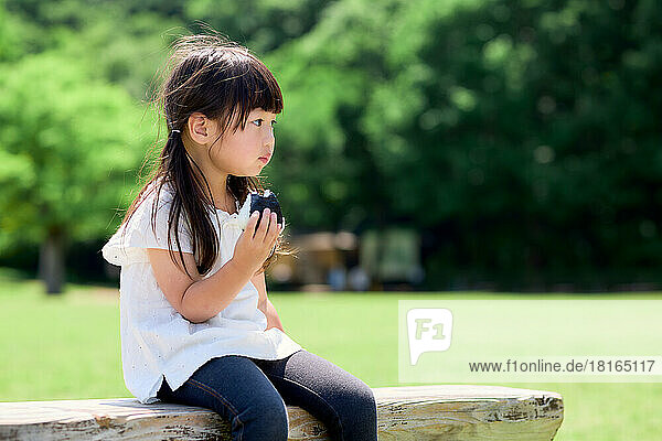 Japanese kid eating at a city park