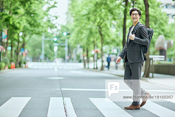 Japanischer Geschäftsmann zu Fuß